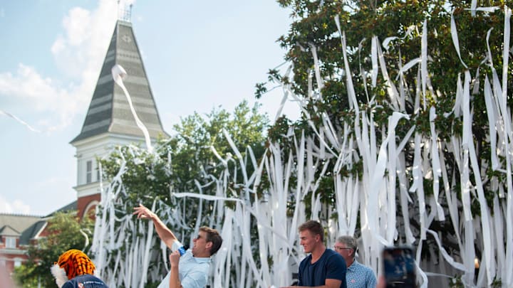 Retired NFL quarterback Eli Manning and former Auburn and Denver Broncos quarterback Bo Nix throw toilet paper during the filming of the ESPN show Eli’s Places at Toomer’s Corner in Auburn, Ala. on Tuesday, July 8, 2025.