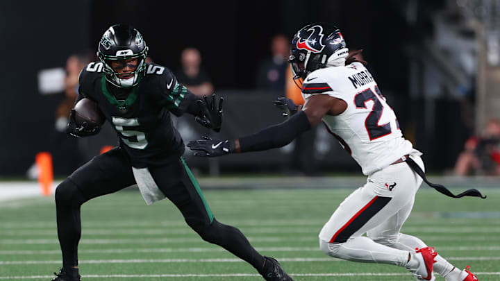 Oct 31, 2024; East Rutherford, New Jersey, USA; New York Jets wide receiver Garrett Wilson (5) runs with the ball against Houston Texans safety Eric Murray (23) during the first half at MetLife Stadium. Mandatory Credit: Ed Mulholland-Imagn Images