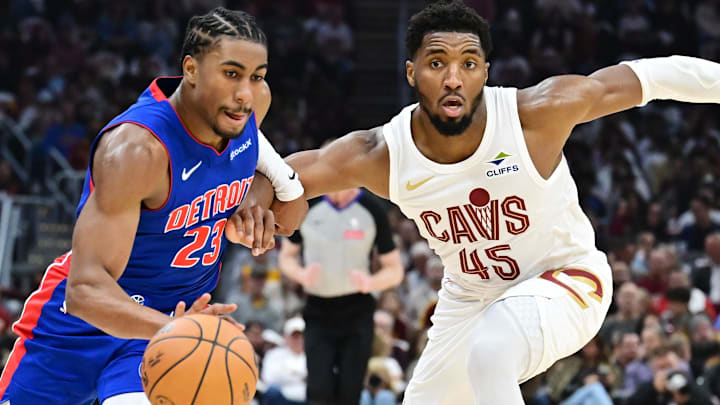 Oct 25, 2024; Cleveland, Ohio, USA; Detroit Pistons guard Jaden Ivey (23) drives to the basket against Cleveland Cavaliers guard Donovan Mitchell (45): Ken Blaze-Imagn Images