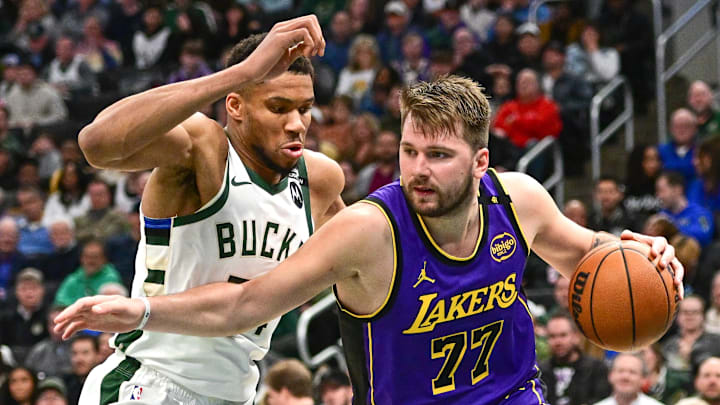 Mar 13, 2025; Milwaukee, Wisconsin, USA;  Los Angeles Lakers guard Luka Doncic (77) drives to the basket against Milwaukee Bucks forward Giannis Antetokounmpo (34) in the third quarter at Fiserv Forum. Mandatory Credit: Benny Sieu-Imagn Images