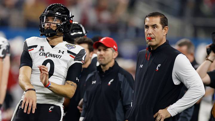 Dec 31, 2021; Arlington, Texas, USA; Cincinnati Bearcats quarterback Desmond Ridder (9) throws a ball while head coach Luke Fickell looks on before the game against the Alabama Crimson Tide at the 2021 Cotton Bowl college football CFP national semifinal game at AT&T Stadium. Mandatory Credit: Tim Heitman-USA TODAY Sports