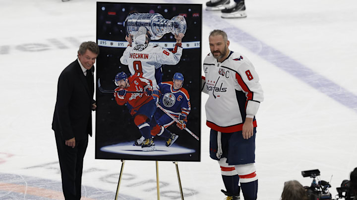 Apr 6, 2025; Elmont, New York, USA;  Washington Capitals left wing Alex Ovechkin (8) is honored with a painting by artist Tony Harris by former Canadian-American ice hockey player Wayne Gretzky after scoring in the during the second period against the New York Islanders at UBS Arena. Ovechkin scored the 895th goal of his career, breaking the NHL all-time career goals record previously held by Wayne Gretzky at UBS Arena. Mandatory Credit: Geoff Burke-Imagn Images
