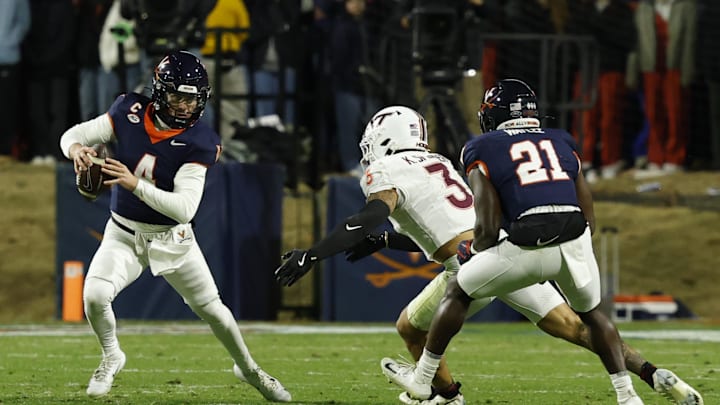 Nov 29, 2025; Charlottesville, Virginia, USA; Virginia Cavaliers quarterback Chandler Morris (4) scrambles from Virginia Tech Hokies linebacker Kaleb Spencer (3) in the second quarter at Scott Stadium. Mandatory Credit: Geoff Burke-Imagn Images