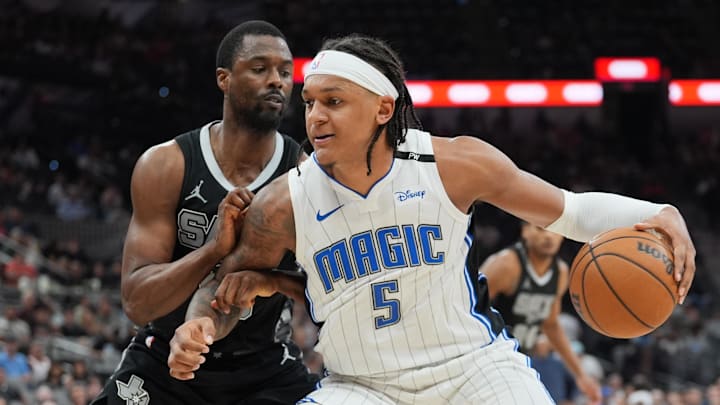 Apr 1, 2025; San Antonio, Texas, USA;  Orlando Magic forward Paolo Banchero (5) dribbles against San Antonio Spurs forward Harrison Barnes (40) in the second half at Frost Bank Center. Mandatory Credit: Daniel Dunn-Imagn Images
