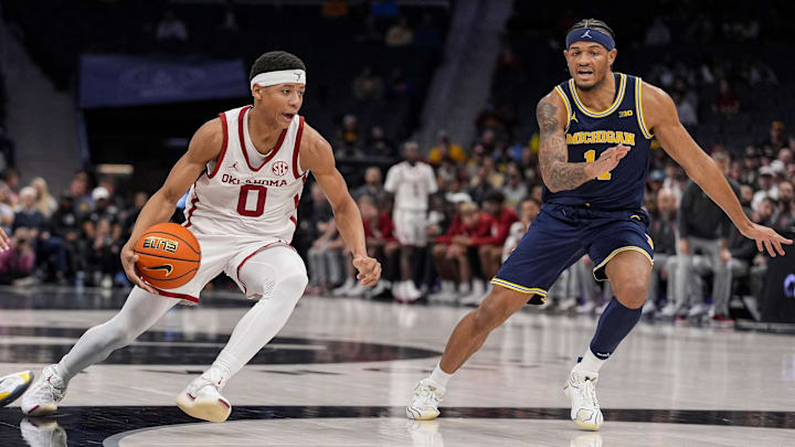 Dec 18, 2024; Charlotte, North Carolina, USA; Oklahoma Sooners guard Jeremiah Fears (0) drives to the basket against Michigan Wolverines guard Roddy Gayle Jr. (11) during the first half at Spectrum Center. Mandatory Credit: Jim Dedmon-Imagn Images