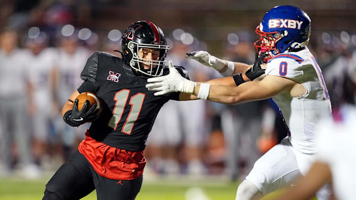 Mustang tries to get by Bixby defender during the high school football game between Bixby and Mustang at Mustang High School in Mustang, Okla., Thursday, Oct. 23, 2025.