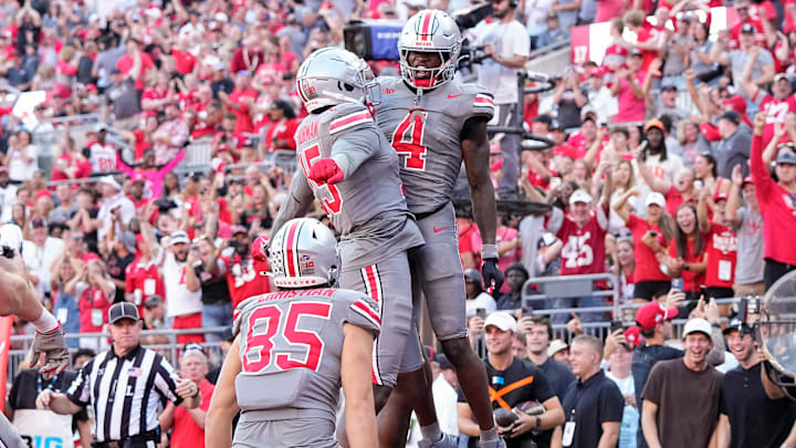 Oct 5, 2024; Columbus, OH, USA; Ohio State Buckeyes wide receiver Jeremiah Smith (4) celebrates a touchdown with tight end Jelani Thurman (15) and tight end Bennett Christian (85) during the second half of the NCAA football game at Ohio Stadium. Ohio State won 35-7. Oct 5, 2024; Columbus, OH, USA; Ohio State Buckeyes wide receiver Jeremiah Smith (4) celebrates a touchdown with tight end Jelani Thurman (15) and tight end Bennett Christian (85) during the second half of the NCAA football game at Ohio Stadium. Ohio State won 35-7.
