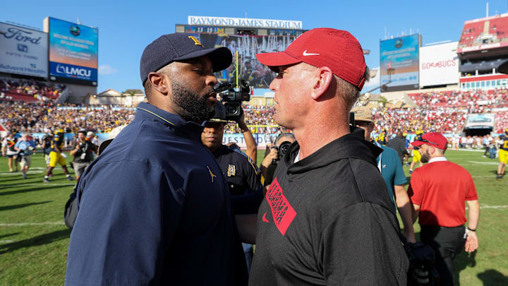 Dec 31, 2024; Tampa, FL, USA;  Michigan Wolverines head coach Sherrone Moore greets Alabama Crimson Tide head coach Kalen Deboer after the ReliaQuest Bowl at Raymond James Stadium. Mandatory Credit: Nathan Ray Seebeck-Imagn Images