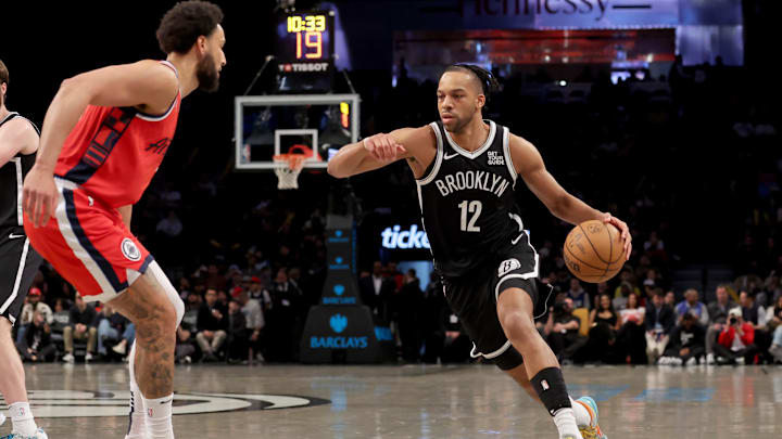 Mar 28, 2025; Brooklyn, New York, USA; Brooklyn Nets forward Tosan Evbuomwan (12) drives to the basket against Los Angeles Clippers guard Ben Simmons (25) during the fourth quarter at Barclays Center. Mandatory Credit: Brad Penner-Imagn Images 