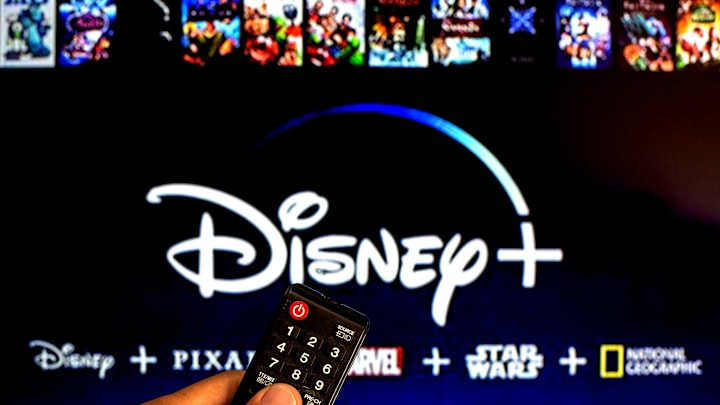 In this photo illustration a close-up of a hand holding a TV...