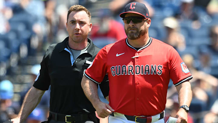 Jun 26, 2025; Cleveland, Ohio, USA; Home plate umpire Tom Hanahan walks Cleveland Guardians manager Stephen Vogt (12) backs to the dugout during the fifth inning against the Toronto Blue Jays at Progressive Field. Mandatory Credit: Ken Blaze-Imagn Images