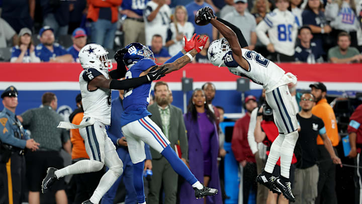 Sep 26, 2024; East Rutherford, New Jersey, USA; Dallas Cowboys cornerback Amani Oruwariye (27) intercepts a pass intended for New York Giants wide receiver Jalin Hyatt (13) in front of Cowboys safety Donovan Wilson (6) during the fourth quarter at MetLife Stadium. 