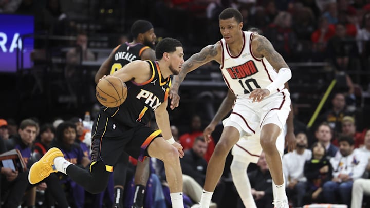 Mar 12, 2025; Houston, Texas, USA; Phoenix Suns guard Devin Booker (1) dribbles the ball as Houston Rockets forward Jabari Smith Jr. (10) defends during the fourth quarter at Toyota Center. Mandatory Credit: Troy Taormina-Imagn Images