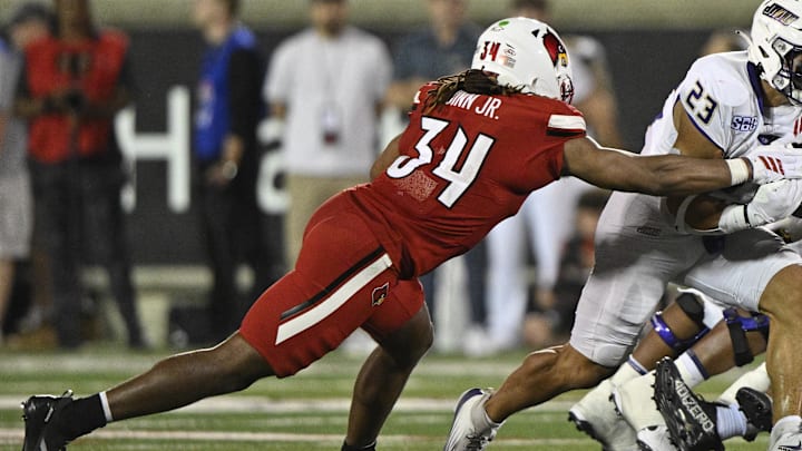 Sep 5, 2025; Louisville, Kentucky, USA;  James Madison Dukes running back Jordan Fuller (23) runs the ball against Louisville Cardinals linebacker TJ Quinn (34) during the second half at L&N Federal Credit Union Stadium. Mandatory Credit: Jamie Rhodes-Imagn Images