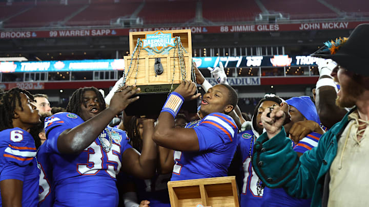 Dec 20, 2024; Tampa, FL, USA; Florida Gators defensive lineman D'Antre Robinson (35) and quarterback DJ Lagway (2)  hold up the Gasparilla Bowl championship trophy after the win against the Tulane Green Wave at Raymond James Stadium. Mandatory Credit: Kim Klement Neitzel-Imagn Images