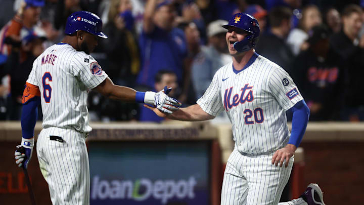 Oct 18, 2024; New York City, New York, USA; New York Mets first baseman Pete Alonso (20) high-fives right fielder Starling Marte (6) after scoring during the fourth inning against the Los Angeles Dodgers during game five of the NLCS for the 2024 MLB playoffs at Citi Field. Mandatory Credit: Vincent Carchietta-Imagn Images