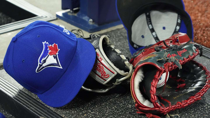 Apr 27, 2024; Toronto, Ontario, CAN; A pair of Toronto Blue Jays hats and gloves in the dugout during the first inning against the Los Angeles Dodgers at Rogers Centre. Mandatory Credit: John E. Sokolowski-Imagn Images