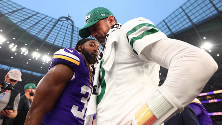 New York Jets quarterback Aaron Rodgers speaks with Minnesota Vikings running back Aaron Jones.