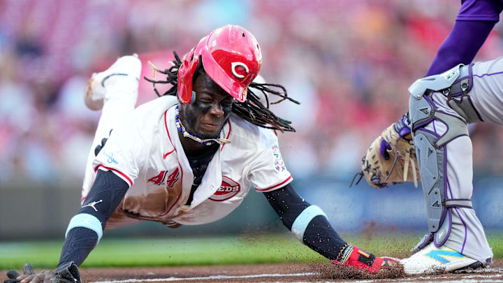 Cincinnati Reds shortstop Elly De La Cruz (44) dives across home plate on a steal attempt but is tagged out by Colorado Rockies catcher Elias Díaz (35) for the final out of the first inning of the MLB National League game between the Cincinnati Reds and the Colorado Rockies at Great American Ball Park in downtown Cincinnati on Monday, July 8, 2024. The score was 0-0 after three innings.