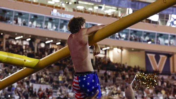 Oct 5, 2024; Nashville, Tennessee, USA;  Vanderbilt Commodores fans take down the goal post after an upset victory over the Alabama Crimson Tide at FirstBank Stadium. Mandatory Credit: Butch Dill-Imagn Images