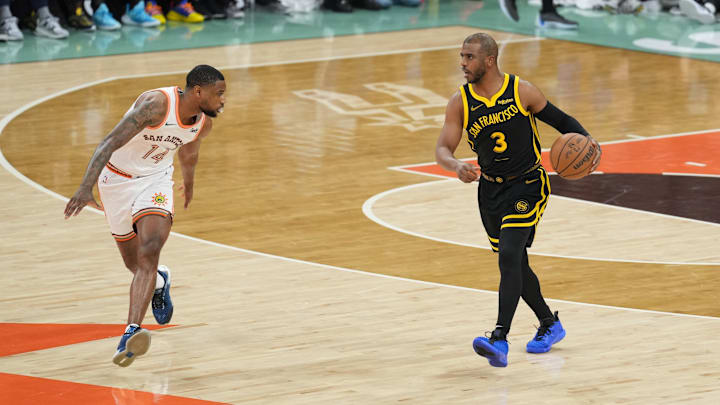 Mar 31, 2024; San Antonio, Texas, USA; Golden State Warriors guard Chris Paul (3) dribbles in front of San Antonio Spurs guard Blake Wesley (14) in the first half at Frost Bank Center.