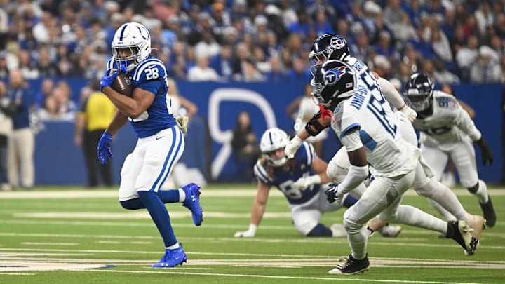 Oct 26, 2025; Indianapolis, Indiana, USA; Indianapolis Colts running back Jonathan Taylor (28) rushes as Tennessee Titans cornerback Jalyn Armour-Davis (18) defends during the first quarter at Lucas Oil Stadium. Mandatory Credit: Robert Goddin-Imagn Images