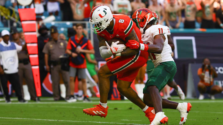 Sep 7, 2024; Miami Gardens, Florida, USA; Miami Hurricanes tight end Elijah Arroyo (8) scores a touchdown against Florida A&M Rattlers defensive back Deco Wilson (11) during the first quarter at Hard Rock Stadium. Mandatory Credit: Sam Navarro-Imagn Images