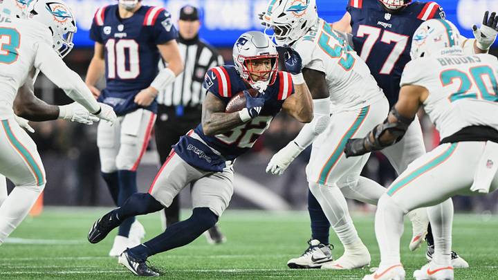 Jan 4, 2026; Foxborough, Massachusetts, USA; New England Patriots running back TreVeyon Henderson (32) runs the ball against Miami Dolphins center Aaron Brewer (55) during the first quarter at Gillette Stadium. Mandatory Credit: Brian Fluharty-Imagn Images Jan 4, 2026; Foxborough, Massachusetts, USA; New England Patriots running back TreVeyon Henderson (32) runs the ball against Miami Dolphins center Aaron Brewer (55) during the first quarter at Gillette Stadium. Mandatory Credit: Brian Fluharty-Imagn Images