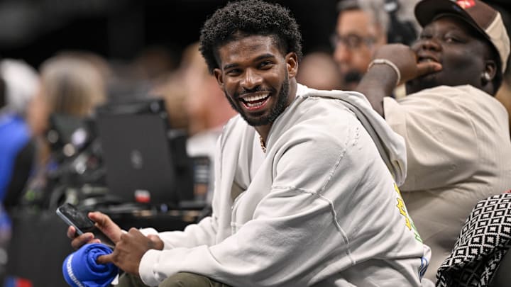 Colorado Buffaloes quarterback Shedeur Sanders laughs as he watches the game between the Dallas Mavericks and the Denver Nuggets.