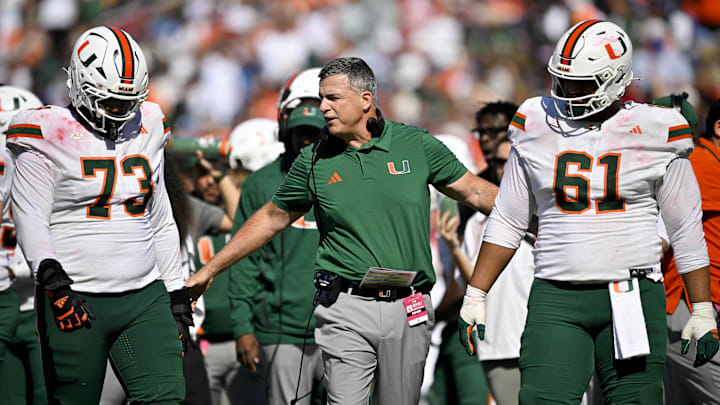 Nov 1, 2025; Dallas, Texas, USA;  Miami Hurricanes head coach Mario Cristobal talks to offensive lineman Anez Cooper (73) and offensive lineman Francis Mauigoa (61) during the second half against the SMU Mustangs at Gerald J. Ford Stadium. Mandatory Credit: Jerome Miron-Imagn Images