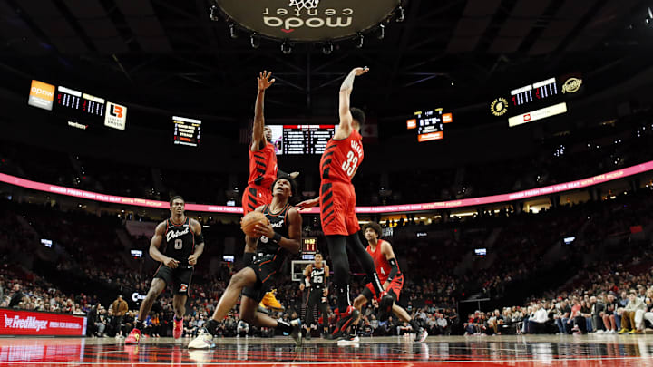 Feb 8, 2024; Portland, Oregon, USA; Detroit Pistons forward Ausar Thompson (9) attempts to score as Portland Trail Blazers small forward Jerami Grant (9, left) and Toumani Camara (33)  defend during the first half at Moda Center. Mandatory Credit: Soobum Im-Imagn Images