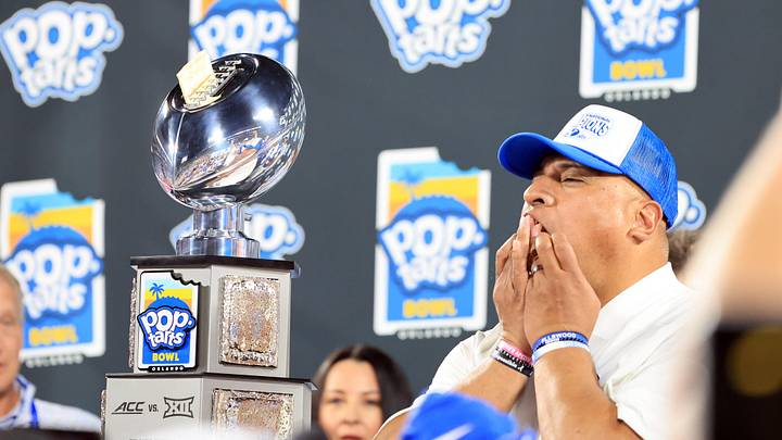 Dec 27, 2025; Orlando, FL, USA; BYU Cougars head coach Kalani Sitake eats a pop-tart and celebrates after they beat the against the Georgia Tech Yellow Jackets at Camping World Stadium. Mandatory Credit: Kim Klement Neitzel-Imagn Images Dec 27, 2025; Orlando, FL, USA; BYU Cougars head coach Kalani Sitake eats a pop-tart and celebrates after they beat the against the Georgia Tech Yellow Jackets at Camping World Stadium. Mandatory Credit: Kim Klement Neitzel-Imagn Images