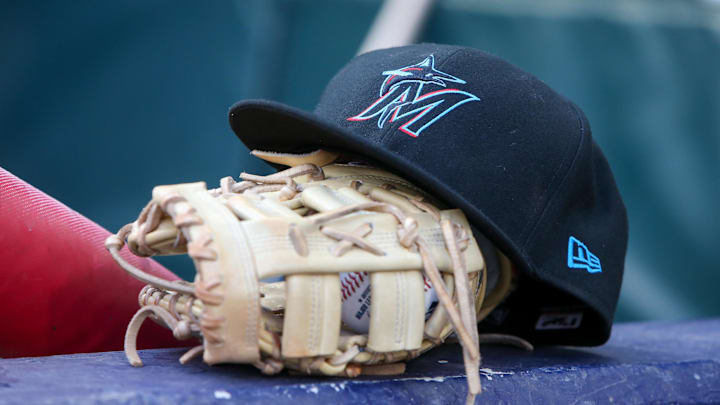 Apr 24, 2024; Atlanta, Georgia, USA; A detailed view of a Miami Marlins hat and glove in the dugout before a game against the Atlanta Braves at Truist Park. 