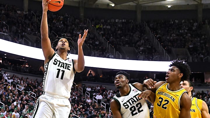 Jan 30, 2024; East Lansing, Michigan, USA; Michigan State Spartans guard A.J. Hoggard (11) gets a slashing layup to go in while teammate center Mady Sissoko (22) and Michigan Wolverines forward Tarris Reed Jr. (32) battle for position during the second half at Jack Breslin Student Events Center. Mandatory Credit: Dale Young-Imagn Images