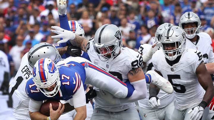 Bills quarterback Josh Allen tries to jump over the Raiders defensive line near the end zone.