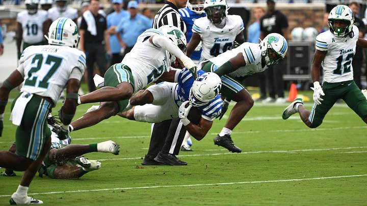 Sep 5, 2026; Durham, North Carolina, USA; Duke Blue Devils running back Nate Sheppard (20) takes a hit from Tulane Green Wave saftey Jack Tchienchou (1) during the first quarter at Wallace Wade Stadium. Mandatory Credit: Zachary Taft-Imagn Images Sep 5, 2026; Durham, North Carolina, USA; Duke Blue Devils running back Nate Sheppard (20) takes a hit from Tulane Green Wave saftey Jack Tchienchou (1) during the first quarter at Wallace Wade Stadium. Mandatory Credit: Zachary Taft-Imagn Images