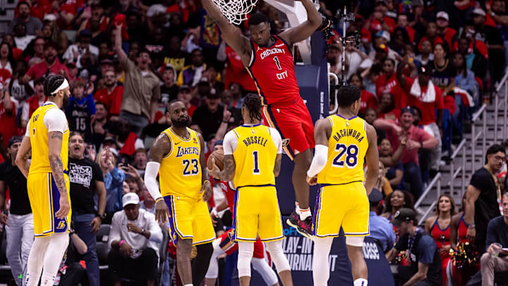 Apr 16, 2024; New Orleans, Louisiana, USA; New Orleans Pelicans forward Zion Williamson (1) dunks the ball against Los Angeles Lakers forward LeBron James (23) and guard D'Angelo Russell (1) during the second half of a play-in game of the 2024 NBA playoffs at Smoothie King Center. Mandatory Credit: Stephen Lew-Imagn Images