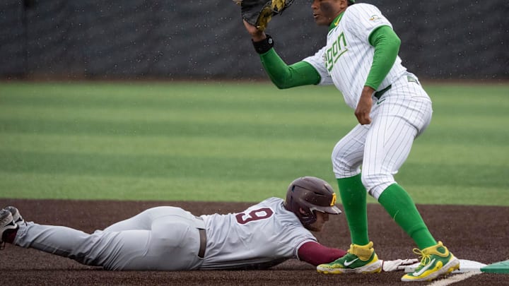 Oregon first baseman Jacob Walsh makes a catch as Minnesota outfielder Parker Knoll dives safely back to first as the Oregon Ducks host the Minnesota Golden Gophers Saturday, March 15, 2025, at PK Park in Eugene, Ore.