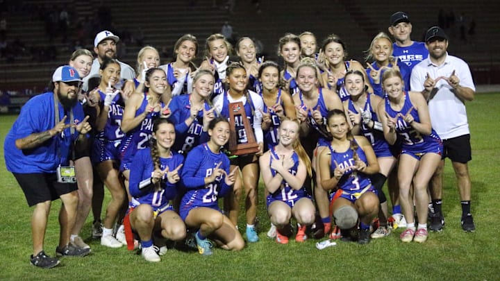 The Pace flag football team celebrates with the trophy after winning the District 1-3A championship game over Niceville on Thursday, April 17, 2025, at Pace High School.