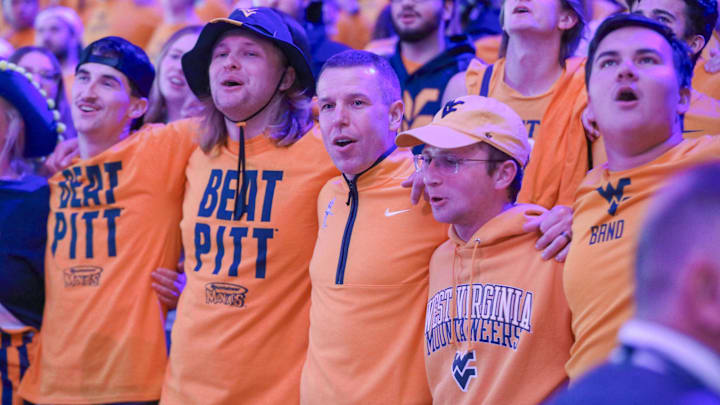 Nov 13, 2025; Morgantown, West Virginia, USA; West Virginia Mountaineers head coach Ross Hodge sings “Country Roads” with students after defeating the Pittsburgh Panthers at WVU Coliseum. Mandatory Credit: Ben Queen-Imagn Images