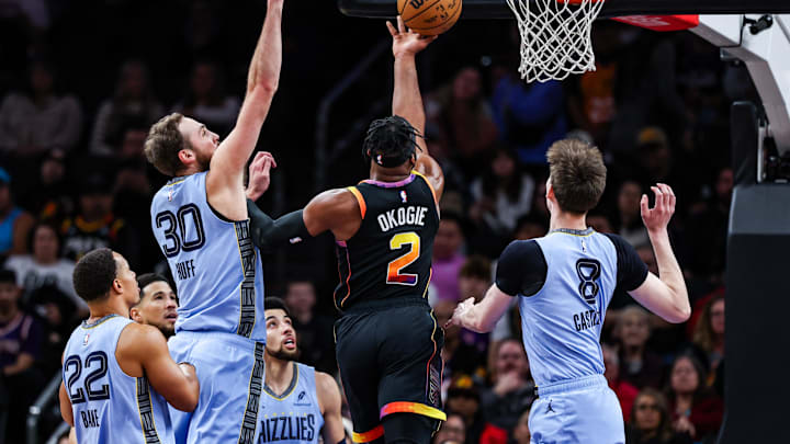 Dec 31, 2024; Phoenix, Arizona, USA; Phoenix Suns guard Josh Okogie (2) makes a lay up while Memphis Grizzlies center Jay Huff (30) fails to block him during the second quarter of the game at Footprint Center. Mandatory Credit: Aryanna Frank-Imagn Images