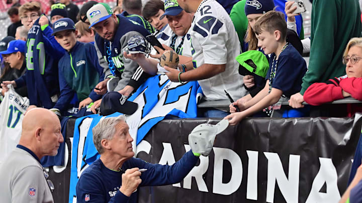 Jan 7, 2024; Glendale, Arizona, USA; Seattle Seahawks head coach Pete Carroll signs items for fans prior to the game against the Arizona Cardinals at State Farm Stadium. Mandatory Credit: Matt Kartozian-Imagn Images