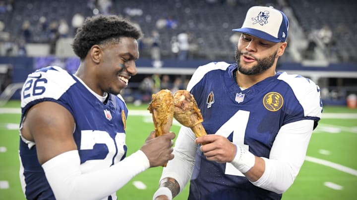 Dallas Cowboys cornerback DaRon Bland and quarterback Dak Prescott eat turkey legs after a Thanksgiving victory. 