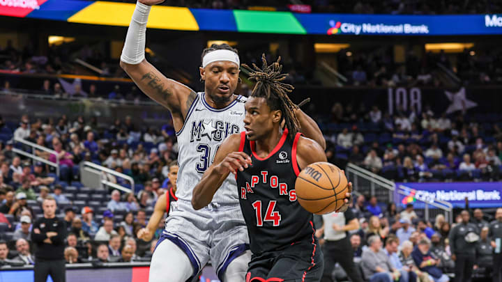 Mar 4, 2025; Orlando, Florida, USA; Toronto Raptors guard Ja'Kobe Walter (14) drives around Orlando Magic center Wendell Carter Jr. (34) during the second half at Kia Center. Mandatory Credit: Mike Watters-Imagn Images
