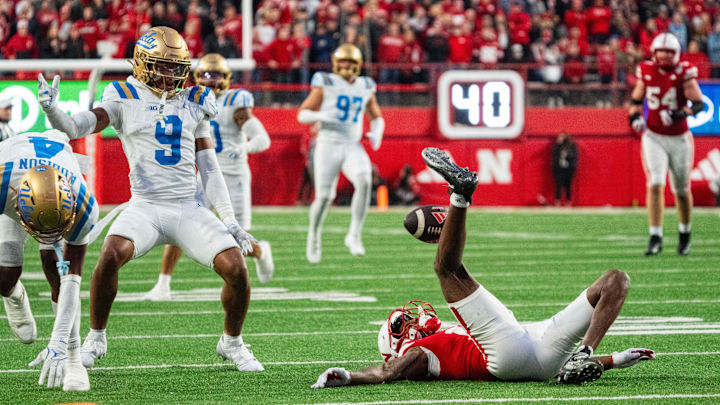 Nov 2, 2024; Lincoln, Nebraska, USA; Nebraska Cornhuskers wide receiver Jacory Barney Jr. (17) kicks the ball up as UCLA Bruins defensive back Kaylin Moore (9) moves to intercept during the fourth quarter at Memorial Stadium. Mandatory Credit: Dylan Widger-Imagn Images
