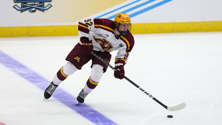Apr 6, 2023; Tampa, Florida, USA; Minnesota forward Logan Cooley (92) controls the puck against Boston University during the second period in the semifinals of the 2023 Frozen Four college ice hockey tournament at Amalie Arena. Mandatory Credit: Nathan Ray Seebeck-Imagn Images