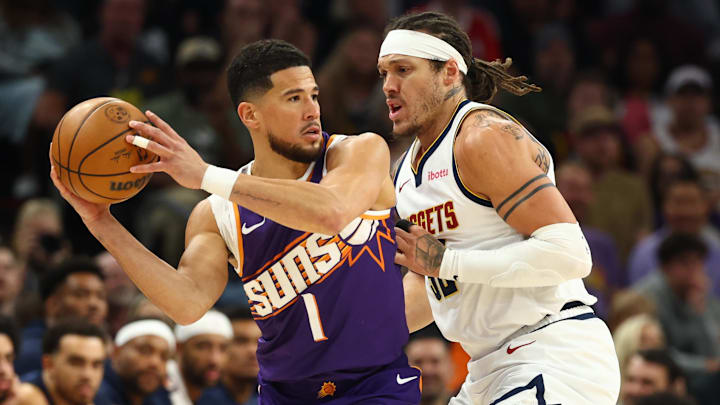 Mar 24, 2026; Phoenix, Arizona, USA; Denver Nuggets forward Aaron Gordon (32) defends against Phoenix Suns guard Devin Booker (1) in the first half at Mortgage Matchup Center. Mandatory Credit: Mark J. Rebilas-Imagn Images