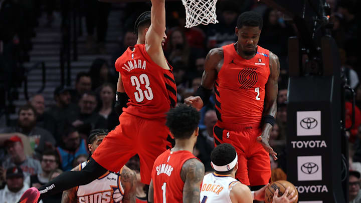 Feb 3, 2025; Portland, Oregon, USA;  Portland Trail Blazers forward Toumani Camara (33) and center Deandre Ayton (2) defend Phoenix Suns guard Devin Booker (1) in the second half at Moda Center. Mandatory Credit: Jaime Valdez-Imagn Images