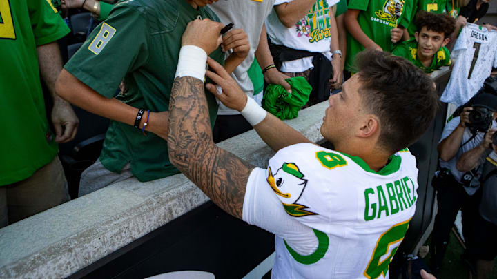 Oregon quarterback Dillon Gabriel autographs the shirt of Josiah Hansen as the Oregon State Beavers host the Oregon Ducks Saturday, Sept. 14, 2024 at Reser Stadium in Corvallis, Ore.