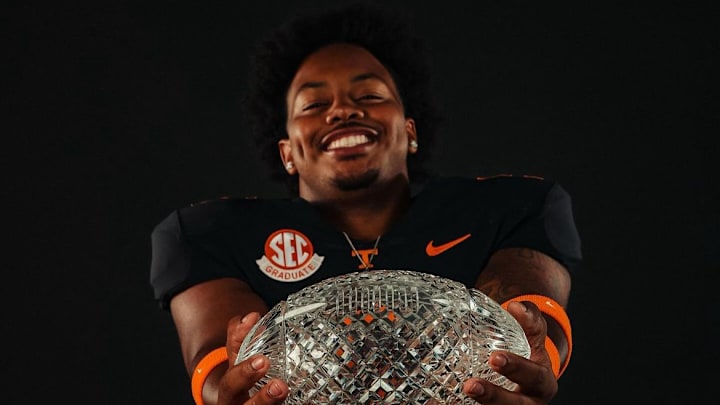 Ethan Utley standing with the Vols national championship trophy.